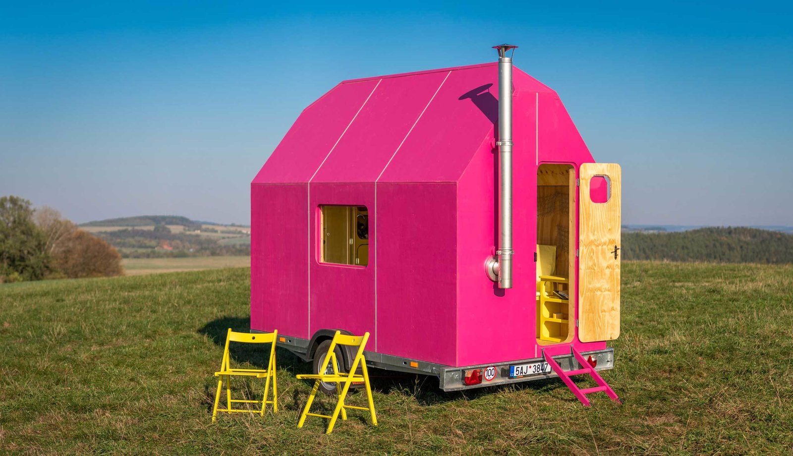 The exuberant hot pink of the Magenta House reveals a calmer, plywood-clad interior.