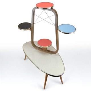 It's hard to get more atomic era than this little side table with black, red, and sky blue floating shelves that would be perfect for plants. The frame of the asymmetrical table is wood, but the top is a Formica laminate edged in metal for a bit of shine.