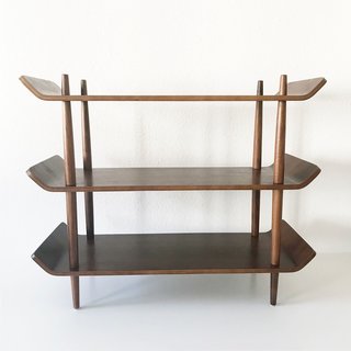 Designed and produced in the Netherlands in 1953, this teak standing shelf could function as either a bookcase or a sideboard in a dining room or living room. The four teak posts are tapered at both the top and the bottom, and the ends of each shelf are turned upwards, exhibiting the bendable properties of plywood. We could see this simple but elegant piece in just about any room!