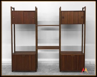 This tripartite walnut unit provides a great mix of open shelving, pull-out drawers, and sliding doors for everything from books and nicknacks to messier items that you want to keep out of sight. The vertically-oriented walnut panels on the bottom drawers keep the piece from feeling too heavy, and the carved walnut handles are particularly lovely.