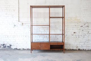 As one of the most influential American midcentury designers, Paul McCobb worked with a variety of furniture companies, but he always brought his notions of proportion, simplicity, and clean lines. This tall wood wall unit from McCobb’s Planner Group line is grounded by a low, solid set of cabinets and a drawer. Above lies a light and airy set of shelves that we could see housing a carefully curated selection of books, vessels, and other objects.