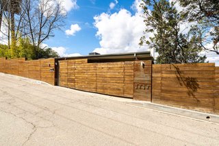 On the street-facing side, the home has a privacy fence made from wood and weathered steel.