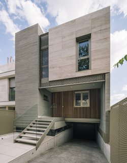 The front facade of the Sierra House mixes concrete, stone, expanded metal mesh, and wood battens.