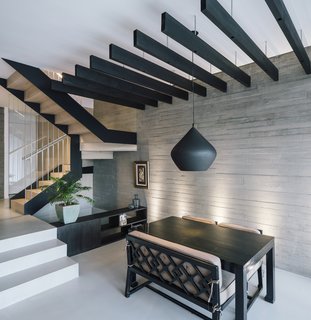 Throughout the home, spaces are defined by changes in ceiling height or floor level—like the battens above the dining table, and the steps down from the hallway to the living and dining area.