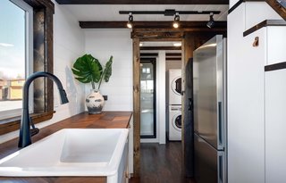 The kitchen's refrigerator and cabinets are efficiently tucked under the steps up to the sleeping loft.