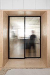 The sliding door between the bedroom and the kitchen is fitted with ribbed glass that allows light through while maintaining privacy.