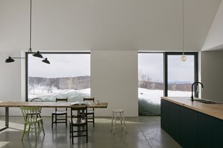 The kitchen and dining area have generously sized windows and a sliding glass door, allowing for a physical and visual connection to the outdoors.