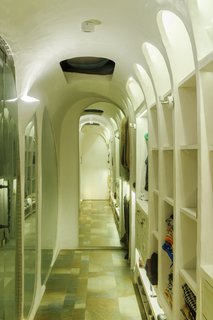 The curves continue into the rest of the apartment via arched ceilings and door openings. Stone flooring is found throughout the apartment as well.