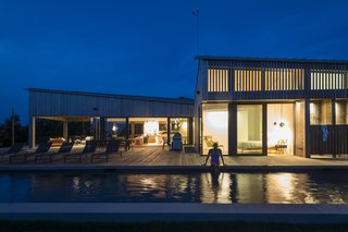 At night, the lap pool glistens in the light from the master suite; an outdoor shower is conveniently located off the pool.