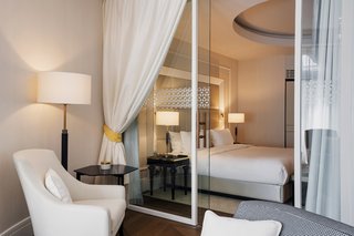 The sparing use of black in the bespoke furniture is reminiscent of the passageway’s walls and thematic coloring. Subtle notes of pale green are used to annotate each room, paired to the same green found in the famous Zsolnay ceramics that adorn numerous historical structures inside and outside of Budapest, including the rooftop of the Paris Court building itself.