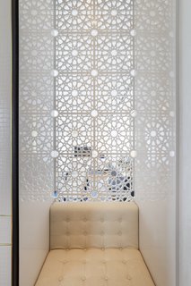 Motifs from the skylight and decorative elements of the arcade were incorporated into many of the public spaces of the hotel, like this niche with a seat and intricate geometric screen behind.
