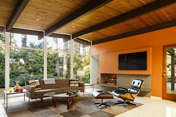 In the interior of a 1950s Portland home, architect Risa Boyer's redesign retained the original post-and-beam construction, exposed wood ceilings, and extensive glass windows but updated the confined galley kitchen and dark, narrow front hallway. The result is a renovation that respected the home's original aesthetic and made it easier for the homeowners to entertain.