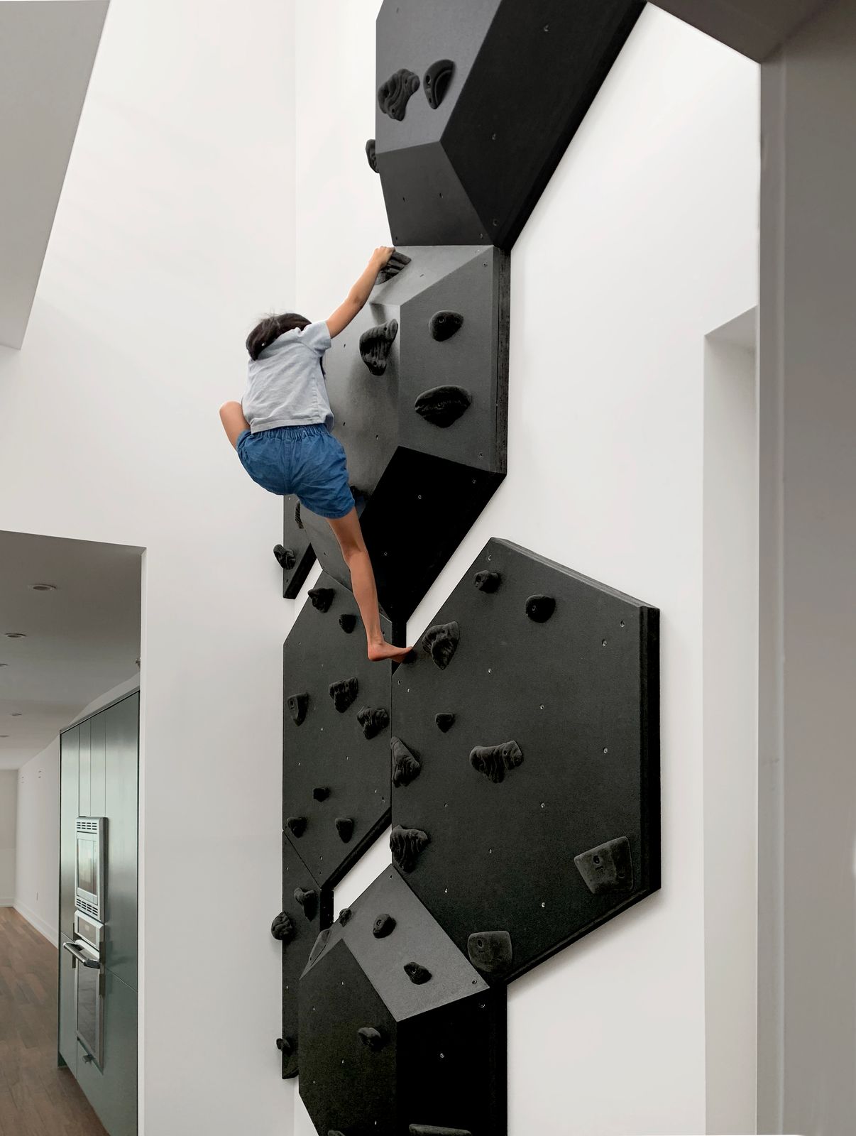 The two-unit home has four bedrooms and six bathrooms across its three stories and 4,200 square feet. The climbing wall is located on the only double-height space in the home, on the third floor near the kitchen.