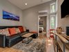 Modern home with Ottomans, Sectional, Console Tables, Coffee Tables, Recessed Lighting, Ceiling Lighting, Medium Hardwood Floor, and Living Room. Each living room features sectional couch with pull out beds, local photography of Pisgah National Forest landmarks, and rug made from recycled plastic bottles. Custom coffee tables and entertainment consoles were created from local timber harvested by the artisans. HVAC mini splits heat and cool the interior spaces. Photo of Pilot Cove : Forest Lodging