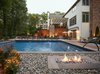 The grade-level custom fire features are constructed out of full masonry with a brownstone cap. These fire features, located on the side of the pool create a harmonious natural balance with the surrounding rock, fire and water. Photo 8 of The Kalimtzis Residence modern home