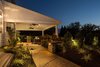 Nighttime is when this backyard really comes alive! The dimmable recessed LED lighting in the roof system provides ample, yet warm light for everything from reading the newest novel to hosting a sit-down dinner with friends and family. Photo 4 of The Plank Residence modern home