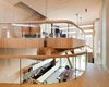The living room is located on the split-level second floor balcony, held up by the tree trunk and secure poles. The kitchen can be seen below.
Photo 2 of Energy Neutral House modern home