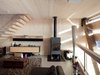 The pellet stove, in the living room area, serves multiple purposes, providing heat for the shower and heating rooms on very cold days. Photo 5 of Energy Neutral House modern home