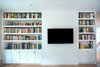 Significant shelf space in both the living room and guest bedroom (not pictured) meet the homeowner's need for ample book storage with additional storage cabinets below. All millwork is custom. Photo 6 of Golden Gate Park Residence modern home
