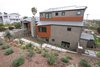 Drought tolerant and native landscaping for water-consciousness in the drought-prone area of San Diego. A rain chain is visible to the right of the chimney. Photo of The Jaska Nolan Residence modern home