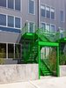 Rear exterior with corrugated metal and bright green railings. Photo 5 of 10th Street Duplexes modern home