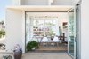 Accordion glass doors open up to create an indoor/outdoor dining and entertaining experience. During the day, natural light floods the main rooms for the kids and animals to play or nap in the sun. Photo 5 of The Beach House modern home