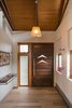 The front door was created with recycled wood beams from the original home, accented with the same boomerang cut-outs from exterior copper canopy. To maximize open floor space, Curtis Micklish designed this floating shelf to catch keys and mail and the occasional tiny toy. Photo 5 of The Modern Mission modern home