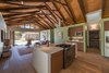 Overhead trusses made from recycled wood beams from the original home support a dramatic 16 foot ceiling. To keep the line of site wide open, an overhead hood was swapped out for a Jenn-air downdraft gas range. Photo 7 of The Modern Mission modern home