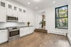 Modern home with Kitchen, Microwave, Dark Hardwood Floor, and White Cabinet. Unit 1 at 137 Atlantic Avenue includes large open kitchen, step-up to living room with fireplace, and wraps around a lovely terrace. $7,595/month. Photo of Bright & Sunny in Brooklyn Heights