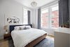 Modern home with Bedroom, Dresser, Bed, Table Lighting, Light Hardwood Floor, and Ceiling Lighting. The master bedroom suite, seen here, includes a luxurious bathroom. Photo 4 of Stunning at Every Angle in Tribeca