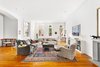 Modern home with Living Room, Sofa, Medium Hardwood Floor, and Ceiling Lighting. The great room is awash in sunlight, adorned by 8 landmarked windows with three exposures - each at least 7 feet tall. Many of the windows have arches with impeccably restored millwork and moldings. The view opens onto the Basilica add gardens of St. Patrick's old Cathedral. Other noteworthy features of the main living area include a decorative fireplace with marble mantle, original cast iron columns, 300-year-old antique long leaf pine flooring reclaimed from beams in a Louisiana textile mill and three-foot-tall custom wainscot baseboards.
Photo of Renovated Co-op in Historic Astor Memorial School