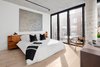 Modern home with Bedroom, Ceiling Lighting, Light Hardwood Floor, and Bed. One of three bedrooms -- complete with concrete structural column. Photo 5 of Curated East Village Penthouse