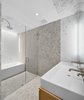Modern home with Bath Room, Porcelain Tile Floor, Enclosed Shower, Soaking Tub, Ceiling Lighting, Ceramic Tile Wall, Drop In Sink, and Vessel Sink. Spacious Carrara marble bathroom with rain shower and separate tub. Photo 6 of Curated East Village Penthouse