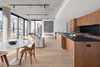 Modern home with Kitchen, Stone Slab Backsplashe, Wall Oven, Refrigerator, Light Hardwood Floor, Wood Cabinet, Ceiling Lighting, and Drop In Sink. Exquisite open kitchens with custom black walnut cabinetry, soapstone countertops and Grohe hardware act as the impressive anchor. Photo 2 of Curated East Village Penthouse