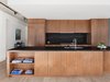 Modern home with Kitchen, Stone Counter, Wall Oven, Refrigerator, Light Hardwood Floor, Drop In Sink, Ceiling Lighting, Stone Slab Backsplashe, and Wood Cabinet. To complete the culinary experience, top of the line appliances by Miele, Wolf and Sub-Zero are provided. Photo 4 of Curated East Village Penthouse