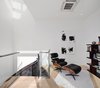Modern home with Office, Bookcase, Chair, Library Room Type, and Light Hardwood Floor. Upstairs, a tranquil seating area drenched in natural light. Photo 10 of Curated East Village Penthouse