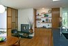 A view of the kitchen addition with its Rais fireplace unit, veneer sunscreen, and custom cabinets and shelves. Photo 3 of Giese House modern home