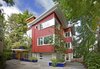 The house from the south, with its irregularly spaced board and batten siding milled from reclaimed lumber. Photo of Sustainable Urban Villa modern home