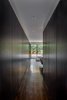 Modern home with Hallway and Dark Hardwood Floor. Panels Covering Closets and Storage - Master Suite - Rift-cut white oak, full-height, honeycomb panels and doors: hand wire brushed, stained, sealed, sanded, glazed, sanded and top-coate Photo 4 of Castro Residence