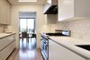 Modern home with Kitchen, Engineered Quartz Counter, Medium Hardwood Floor, White Cabinet, Ceiling Lighting, Ceramic Tile Backsplashe, Range Hood, Range, and Undermount Sink. Galley kitchen - BlueStar range, Neolith countertops, Santos dimensional rhomboid backsplash tile Photo 9 of Lyon Residence
