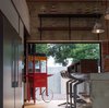 High stools at the kitchen counter are meant for casual dining and the popcorn pushcart adds character to the industrial look of the kitchen Photo 7 of Plantation House modern home