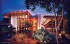 Curved forms made of 2X's & plywood, wrapped with synthetic stucco, trimmed in Redwood and Copper. The sunshade stretched btwn glu-lam beams capped with copper flagpole finials. Photo of Biltmore Deluxe Cabana modern home