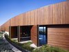 The front door and pivoting wall panels transform this façade when opened, presenting views of the interior, the courtyard and the ocean beyond. Photo 2 of Ziering Residence modern home