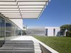 Staring back at the house from its private landscape, a transparent glass main level is topped by the master and family bedrooms. Photo 2 of Oberfeld Residence modern home