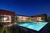 The design forms a C-shaped box that wraps around creating a courtyard. To enclose the central public space of the home, a glass pavilion has been inserted within the courtyard. Photo of Nightingale Residence modern home
