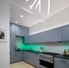 Modern home with Kitchen, Colorful Cabinet, Light Hardwood Floor, Accent Lighting, Pendant Lighting, Refrigerator, Range, Range Hood, Dishwasher, Recessed Lighting, and Undermount Sink. House parties are a regular event here and inspired many of our design decisions. The front door opens directly into the kitchen - the center of party action. I designed the cabinetry as a geometric composition that plays off the art and the feel of a gallery home. Photo 2 of Art and Light