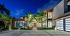 The home's front entrance features wood details and an abundance of glass. Photo of North Bay Road Residence modern home