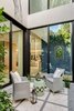 An atrium in the center of the residence allows for a cozy and bright outdoor seating area while still inside the home. Photo 13 of North Bay Road Residence modern home