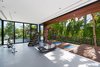 The home's indoor gym makes you feel as if you're outside with its vast pocketing sliding glass doors that open up to a custom yoga deck. Photo 14 of North Bay Road Residence modern home