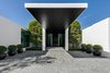 A cantilevered canopy measuring 24 feet greets guests at the home's front entrance. Photo of Ponce Davis Residence modern home